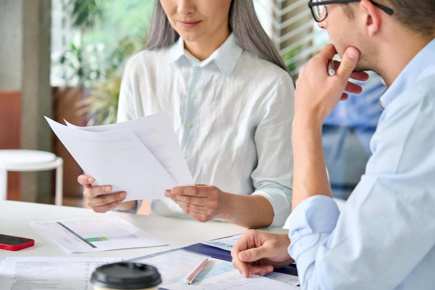 Two colleagues reviewing an employee talent assessment report at an office desk in the UAE
